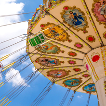 青空の下でカラフルな色の遊園地のアトラクションの写真